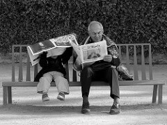 boy and grandfather reading on bench